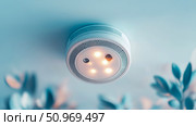 Advanced white smart home smoke and carbon monoxide detector with glowing integrated LED lights mounted on a light blue ceiling, representing modern home safety technology. Стоковое AI-изображение, AI-художник Данила Большаков / Фотобанк Лори
