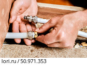 Compression ring is being positioned onto end of multilayer pipe by plumber preparing connection using metal fitting for domestic plumbing line. Стоковое фото, фотограф Владимир Григорьев / Фотобанк Лори