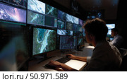 Tech specialists analyze environmental data in a high-tech control room during nighttime operations. Стоковое AI-изображение, AI-художник Сергей Толмачёв / Фотобанк Лори