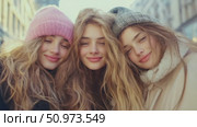 Close-up of three smiling young women wearing winter hats and warm clothing, showcasing friendship and youthful joy outdoors. Стоковое AI-видео, аниматор Данила Большаков / Фотобанк Лори