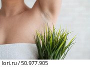 Faceless woman in a white towel holds a pot with a plant. Unrecognizable girl with the help of green bushes imitates the vegetation of armpit hair. Depilation area. Female hair removal. Стоковое фото, фотограф Михаил Решетников / Фотобанк Лори