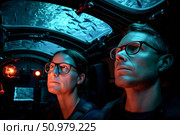 The interior of a deep-sea bathyscaphe, scientists watching marine life through a porthole. Стоковое AI-изображение, AI-художник Алексей Кузнецов / Фотобанк Лори