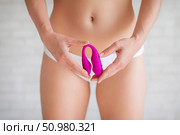 A faceless woman in white panties holds a curved pink clitoral vaginal vibrator. Female sex toy for masturbation. Self-gratification. Demonstrates dildo. Стоковое фото, фотограф Михаил Решетников / Фотобанк Лори