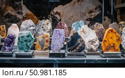 Colorful polished mineral and gemstone slabs displayed in a showroom. Стоковое AI-изображение, AI-художник Катерина Бондарец / Фотобанк Лори