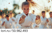 Young girl in karate gi practicing martial arts outdoors in golden light. Стоковое AI-изображение, AI-художник Данила Большаков / Фотобанк Лори