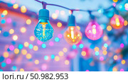 Enchanted Evening: Colorful String Lights Gleaming in the Dusk. Стоковое AI-изображение, AI-художник Данила Большаков / Фотобанк Лори