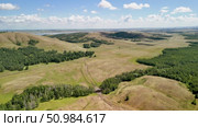 Bannoe Center, Russian Federation - July 27, 2025: Expansive golden grassland landscape under a bright blue sky with fluffy clouds and distant mountains, showcasing the beauty of nature and tranquility. Редакционное видео, видеограф Ирина Ручушкина / Фотобанк Лори