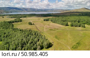 Bannoe Center, Russian Federation - July 27, 2025: Expansive aerial view of lush green forest and rolling hills under bright blue sky showcasing natural beauty and tranquility. Редакционное видео, видеограф Ирина Ручушкина / Фотобанк Лори