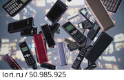 Vintage mobile phones scattered against blurred nighttime cityscape, highlighting technological evolution and communication memories. Стоковое AI-видео, аниматор Данил Руденко / Фотобанк Лори