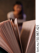 Девушка на заднем плане размыта и читает книгу. На переднем плане страницы книги. Стоковое фото, фотограф Игорь Смирнов / Фотобанк Лори