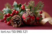 Festive holiday decoration featuring red ornament, pinecone, and greenery on rich background. Стоковое AI-изображение, AI-художник Гайфуллина Дина / Фотобанк Лори