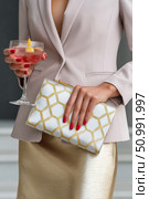 Businesswoman holding cocktail and clutch bag at corporate event. Стоковое фото, фотограф Юрий Поздников / Фотобанк Лори