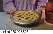 Woman presenting freshly baked apple pie with lattice crust in cozy kitchen setting. Стоковое видео, видеограф Zakharova Natasha / Фотобанк Лори