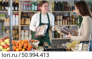 Saleswoman in a supermarket offers various sweets to the buyer near the counter. Buyer chooses natural low-calorie desserts. Стоковое видео, видеограф Яков Филимонов / Фотобанк Лори
