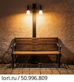 Soft light spills from vintage lanterns, illuminating a wooden bench against a textured wall, inviting night wanderers to pause and reflect in peaceful surroundings Generative AI. Стоковое AI-изображение, AI-художник Юлия Петровская / Фотобанк Лори