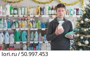 On New Year Eve, man choose glass cleaner for allergy sufferers. Стоковое видео, видеограф Яков Филимонов / Фотобанк Лори
