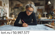 Architect works diligently in design studio creating detailed blueprints for modern building projects. Стоковое AI-видео, аниматор Сергей Толмачёв / Фотобанк Лори