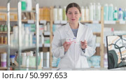 Smiling female pharmacist in white coat confidently recommending paracetamol as safe and effective pain and fever relieve agent, alternative to ibuprofen, explaining benefits at counter in pharmacy. Стоковое видео, видеограф Яков Филимонов / Фотобанк Лори