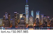 Manhattan skyline glowing at night, One World Trade Center rising above cityscape, illuminating dark waters with dramatic urban reflections and architectural brilliance. Стоковое AI-видео, аниматор Данил Руденко / Фотобанк Лори