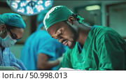Surgeons perform a complex procedure in a modern operating room during a busy hospital shift. Стоковое AI-видео, аниматор Сергей Толмачёв / Фотобанк Лори