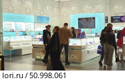 A Bustling Jewelry Store Scene Captured in Two Frames, Featuring Customers Engaging with Staff Amidst Elegant Displays of Sparkling Accessories and Unique Designs. Стоковое видео, видеограф Владимир Федоров / Фотобанк Лори