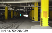 Exploring the Architectural Features of a Modern Parking Garage with Bold Yellow Supports and Clear Sightlines to the Exit. Стоковое видео, видеограф Владимир Федоров / Фотобанк Лори
