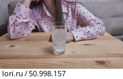 Woman dissolving effervescent tablet in glass of water on wooden table. Стоковое видео, видеограф Дмитрий Цветков / Фотобанк Лори