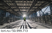Construction worker wearing protective gear standing between metal scaffolding, sunlight casting dramatic shadows across industrial workplace environment. Стоковое AI-видео, аниматор Данил Руденко / Фотобанк Лори