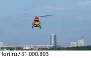 Friendly spectators wave to the medical helicopter pilots as they perform stunts and aerobatic maneuvers during the airshow. Стоковое видео, видеограф Strunov David / Фотобанк Лори