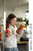 Teen girl hold packages bottles and choose consider juice in store. Стоковое видео, видеограф Яков Филимонов / Фотобанк Лори