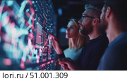 Team analyzes data trends in tech lab during evening session. Стоковое AI-видео, аниматор Сергей Толмачёв / Фотобанк Лори