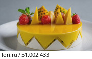 Rotating mango cake decorated with fresh fruits on white background. Стоковое AI-видео, аниматор Юрий Поздников / Фотобанк Лори