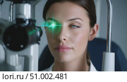 Young woman undergoing eye examination with green laser light. Стоковое AI-видео, аниматор Юрий Поздников / Фотобанк Лори