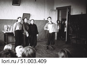 Концерт самодеятельности в деревенской школе, 1950-е годы. Три девушки поют  и молодой человек играет на баяне. Зрители заглядывают в дверь школьного класса. Стоковое фото, фотограф Retro / Фотобанк Лори