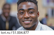 A cheerful young man smiles warmly while interacting with friends, creating an uplifting atmosphere during a casual gathering. Стоковое AI-видео, аниматор Данила Большаков / Фотобанк Лори