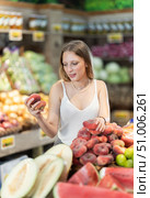 Woman near vegetable stand in store choose flat peach. Стоковое фото, фотограф Яков Филимонов / Фотобанк Лори