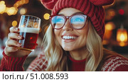 A joyful young woman smiles brightly while holding a festive drink in a warm, decorated environment during the holiday season. Стоковое AI-видео, аниматор Данила Большаков / Фотобанк Лори