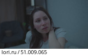 A young adult woman sits on a couch in the middle of the night, nervously twirling her hair. Panic attacks and mental health. Стоковое видео, видеограф Денис Кебедов / Фотобанк Лори