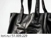 Black leather jacket with zippers and pockets and black leather stylish bag. Modern outerwear. Close-up. Fashion background. Autumn urban street clothes. Fashionable concept. Women's casual day outfit. Стоковое AI-изображение, AI-художник Марина Демидюк / Фотобанк Лори