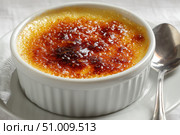 Creme brulee. dessert with caramel crust. Elegant Gourmet Dessert with Caramelized Sugar Crust. French vanilla cream. Eating Creme Brulee with Spoon. Cracking caramel. Delicious Sweet. Catalan cream. Стоковое AI-изображение, AI-художник Марина Демидюк / Фотобанк Лори