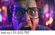An enthusiastic gamer expresses intense emotions amidst a lively arcade environment filled with bright lights and excitement. Стоковое AI-видео, аниматор Данила Большаков / Фотобанк Лори