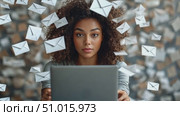 A woman intensely focuses on her laptop as floating envelopes surround her, symbolizing digital communication in a vibrant workspace. Стоковое AI-видео, аниматор Данила Большаков / Фотобанк Лори