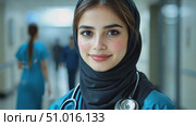 A healthcare professional in a hijab smiles confidently while working in a bustling hospital corridor during the day. Стоковое AI-видео, аниматор Данила Большаков / Фотобанк Лори
