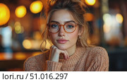 A stylish woman with glasses and a sweater is posing thoughtfully in a cozy cafe filled with warm light during the evening. Стоковое AI-видео, аниматор Данила Большаков / Фотобанк Лори