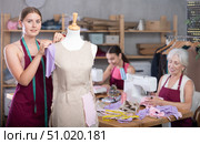 Mature head of manufacturing and female assistant sewing, young designer work with mannequin. Стоковое фото, фотограф Яков Филимонов / Фотобанк Лори