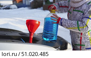 Driver pours winter windshield fluid into the car. Стоковое видео, видеограф Igor Skripachev / Фотобанк Лори