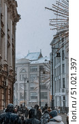Moscow, Russia - January 05, 2025: People at the city street under snow with New Year decorations. Редакционное фото, фотограф Софья Соломонова / Фотобанк Лори