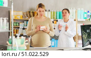 Pregnant woman choosing pills with help of pharmacist. Стоковое видео, видеограф Яков Филимонов / Фотобанк Лори