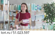 Young woman chooses feminine pads at pharmacy. Стоковое видео, видеограф Яков Филимонов / Фотобанк Лори