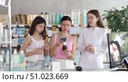 Positive family of adult woman and young girl choosing medicinal cough liquid syrup and scan QR code on label at pharmacy, young woman pharmacist consulting customers. Стоковое видео, видеограф Яков Филимонов / Фотобанк Лори